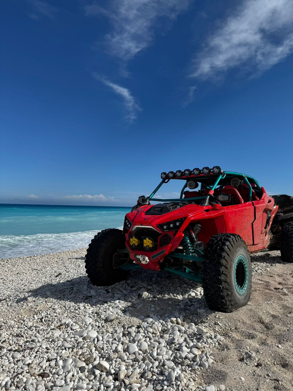 RZR rojo en playa de pebble blanco, costa sur